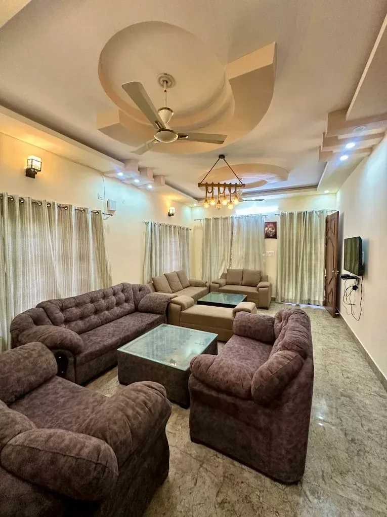 Spacious and comfortably furnished drawing room with plush seating and warm ambient lighting.