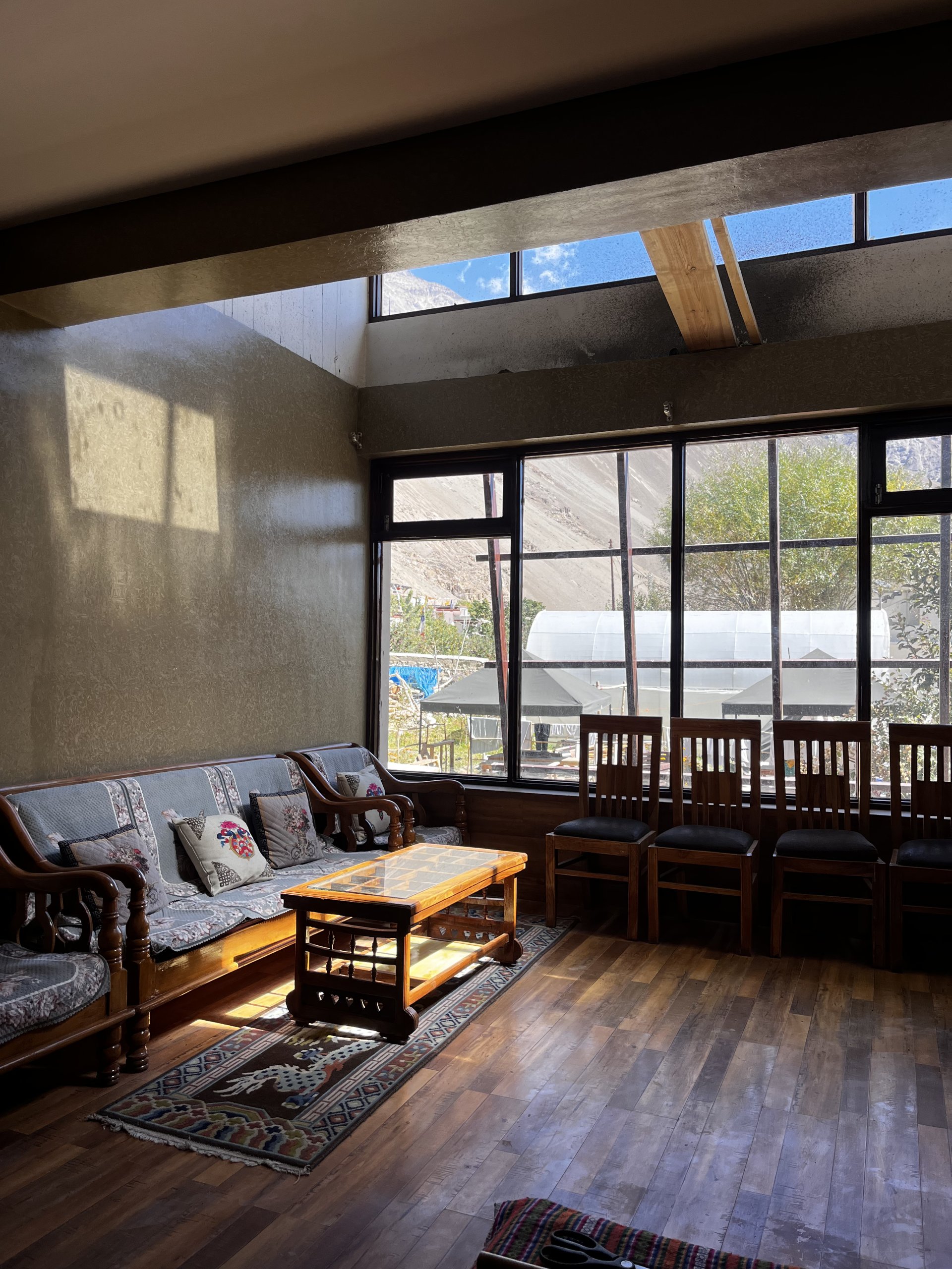 Cozy and inviting common room area at White Lotus Homes in Tabo, featuring traditional wooden architecture, comfortable