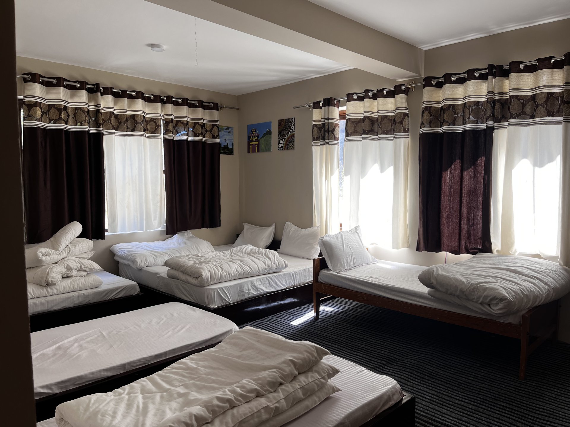 Spacious and comfortable family suite at White Lotus Homes, Tabo, featuring cozy bedding and traditional wood accents.