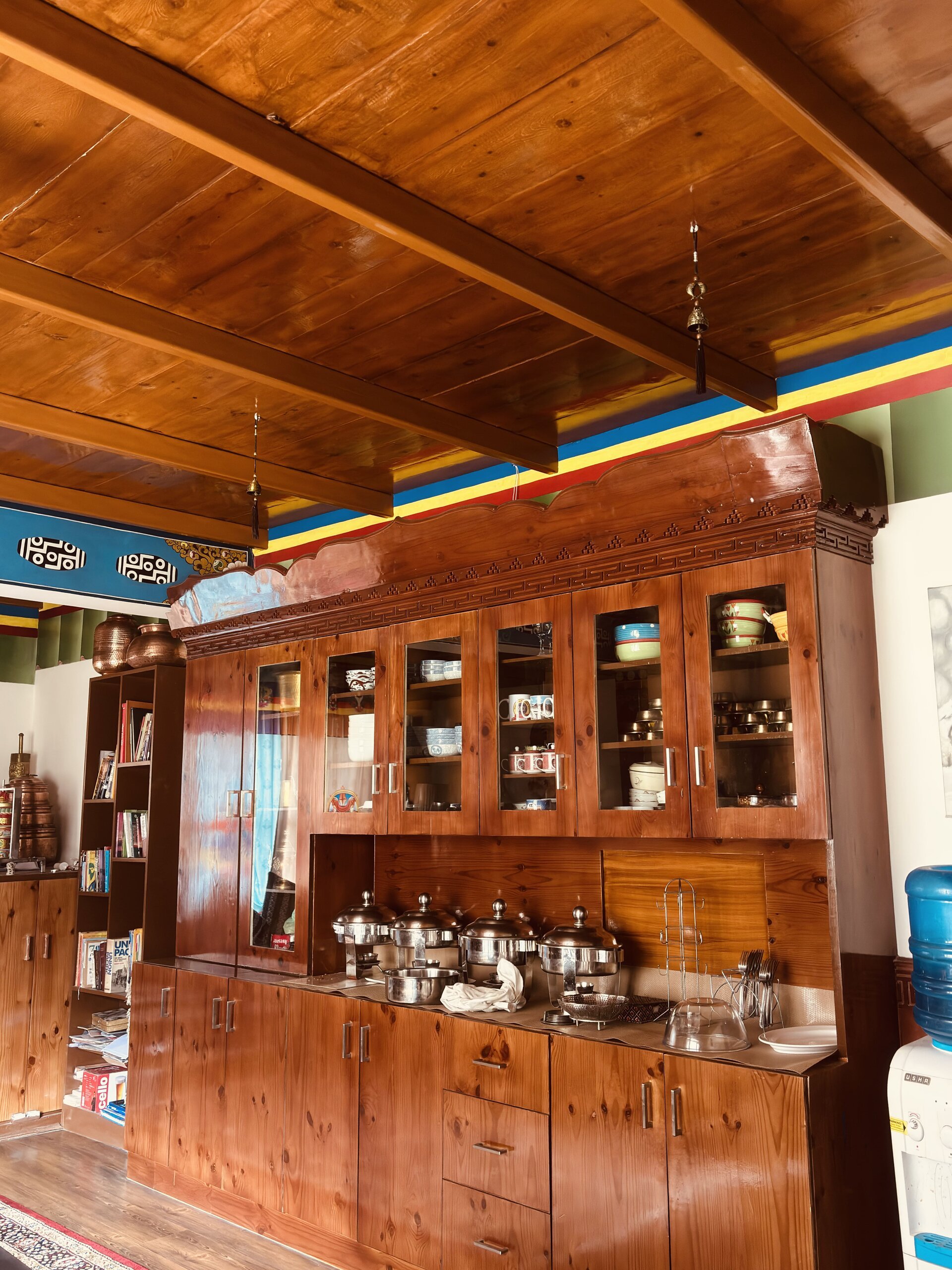 Traditional wooden interiors and warm bar counter details at White Lotus Homes in Tabo.