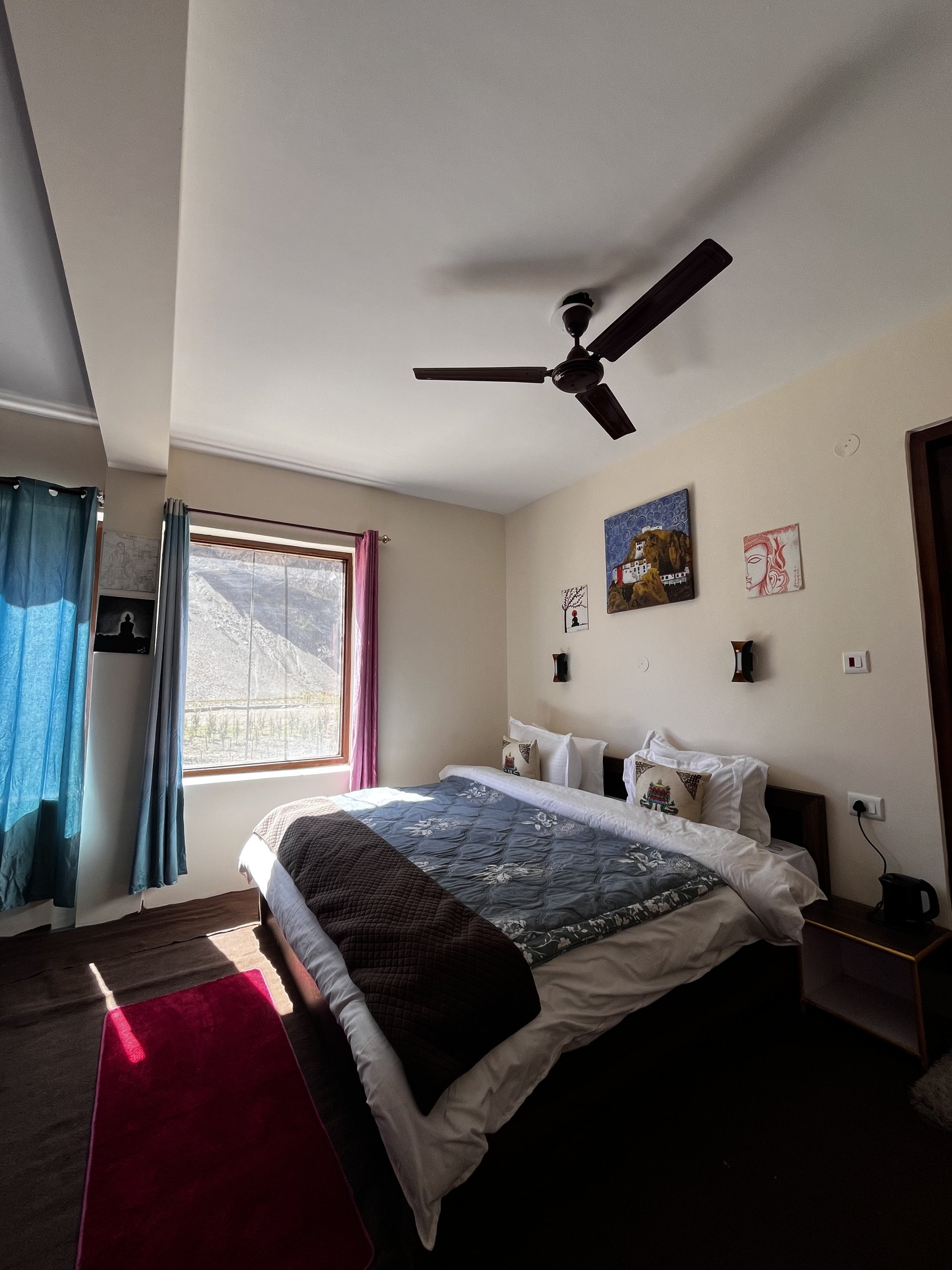 Cozy and warm room interior at White Lotus Homes in Tabo, featuring traditional wooden architecture and a scenic mountai
