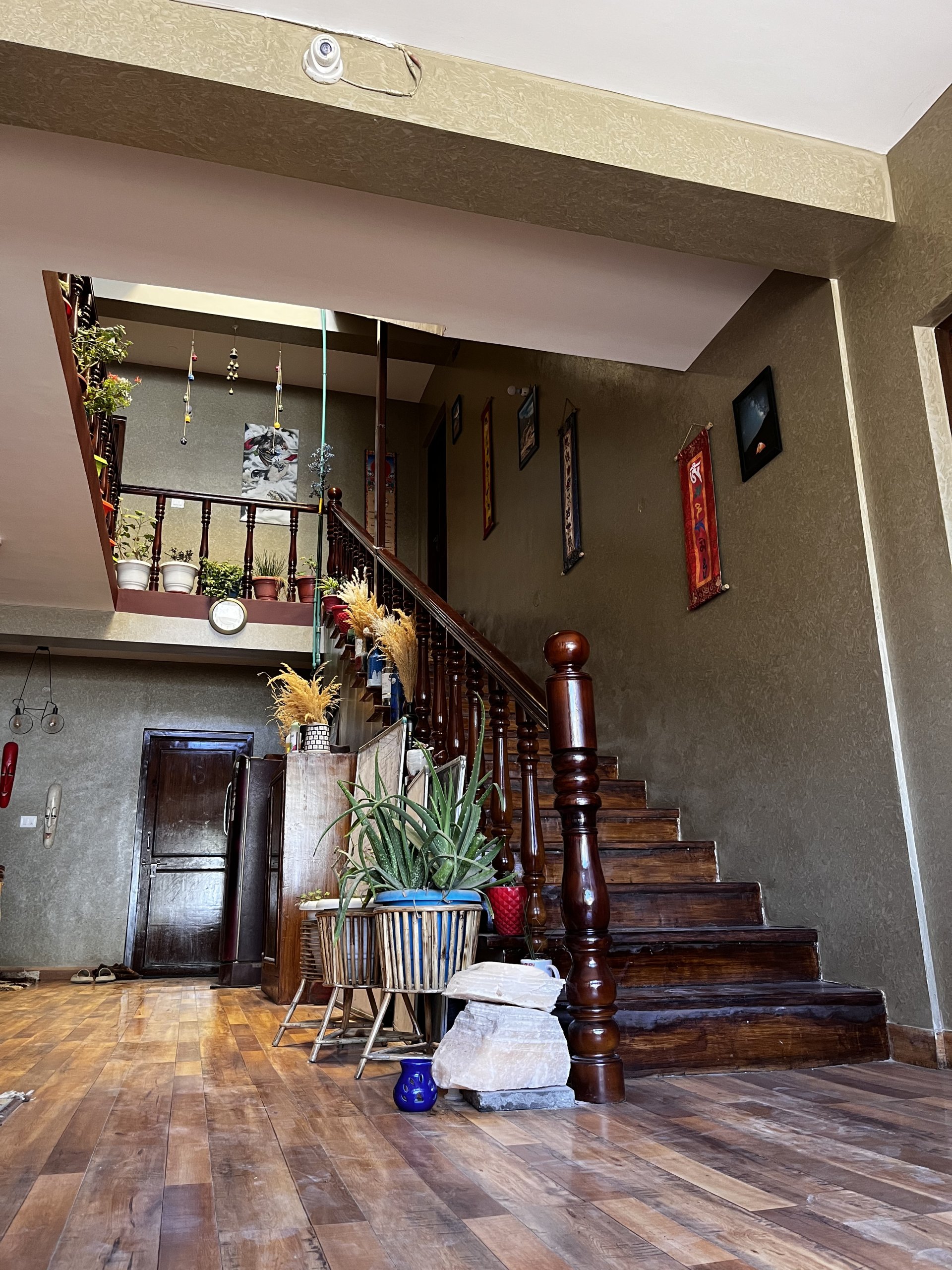 Charming wooden staircase and warm interior decor at White Lotus Homes in Tabo, highlighting traditional Himalayan archi