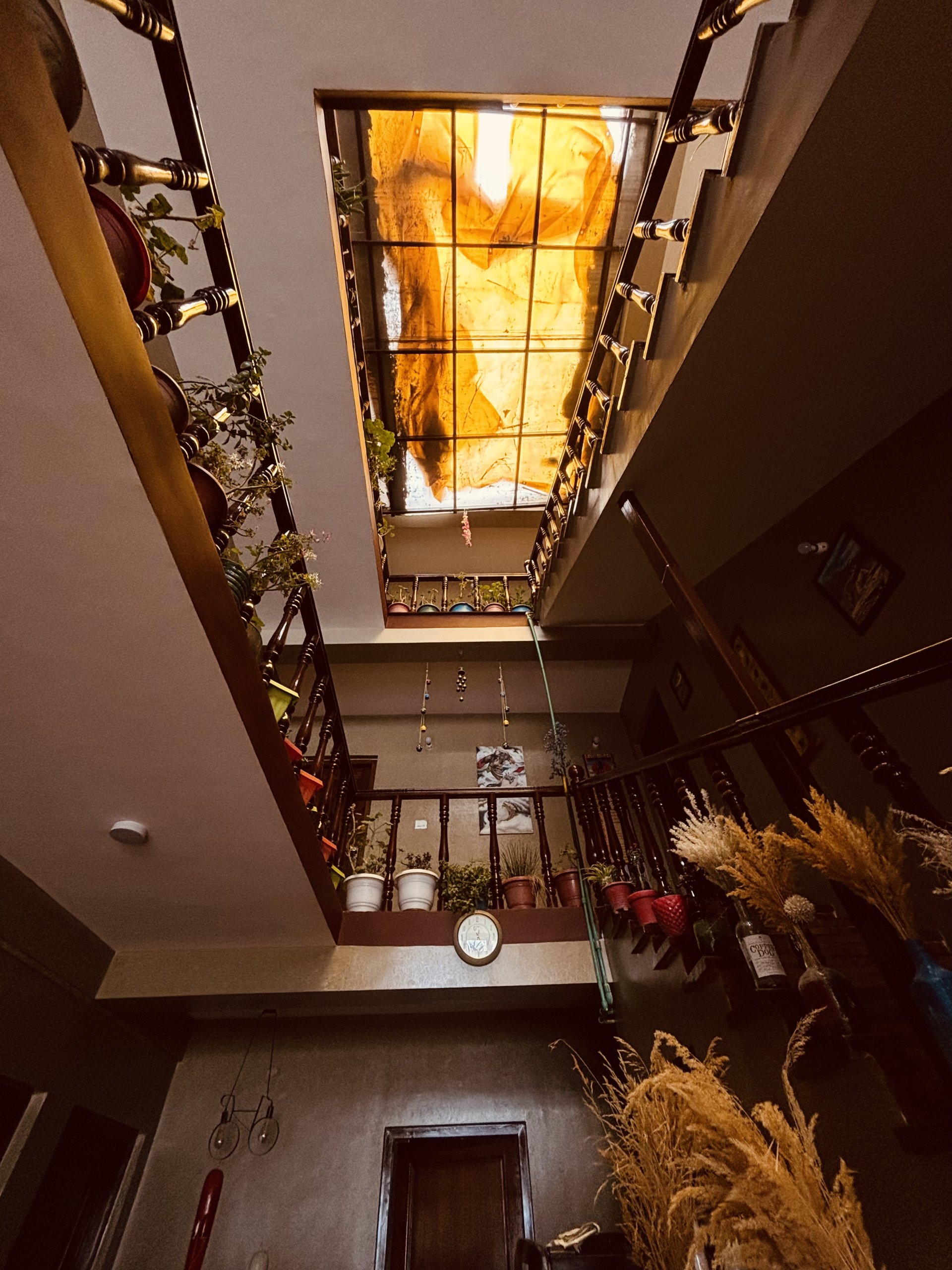 Charming wooden staircase and warm interior decor at White Lotus Homes in Tabo, highlighting traditional Himalayan archi