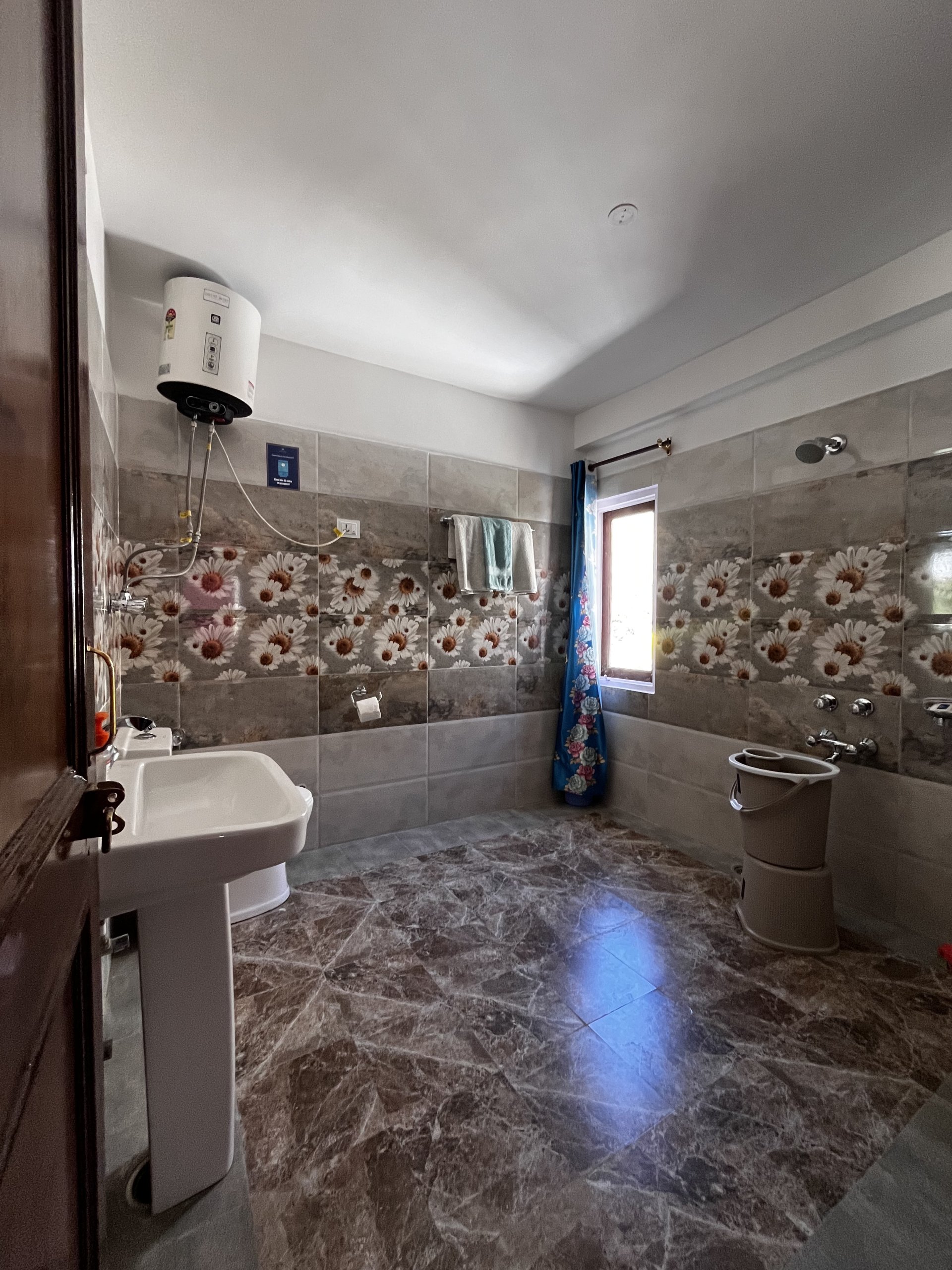 Modern and clean washroom facilities at White Lotus Homes in Tabo, featuring contemporary fixtures and hot water access.