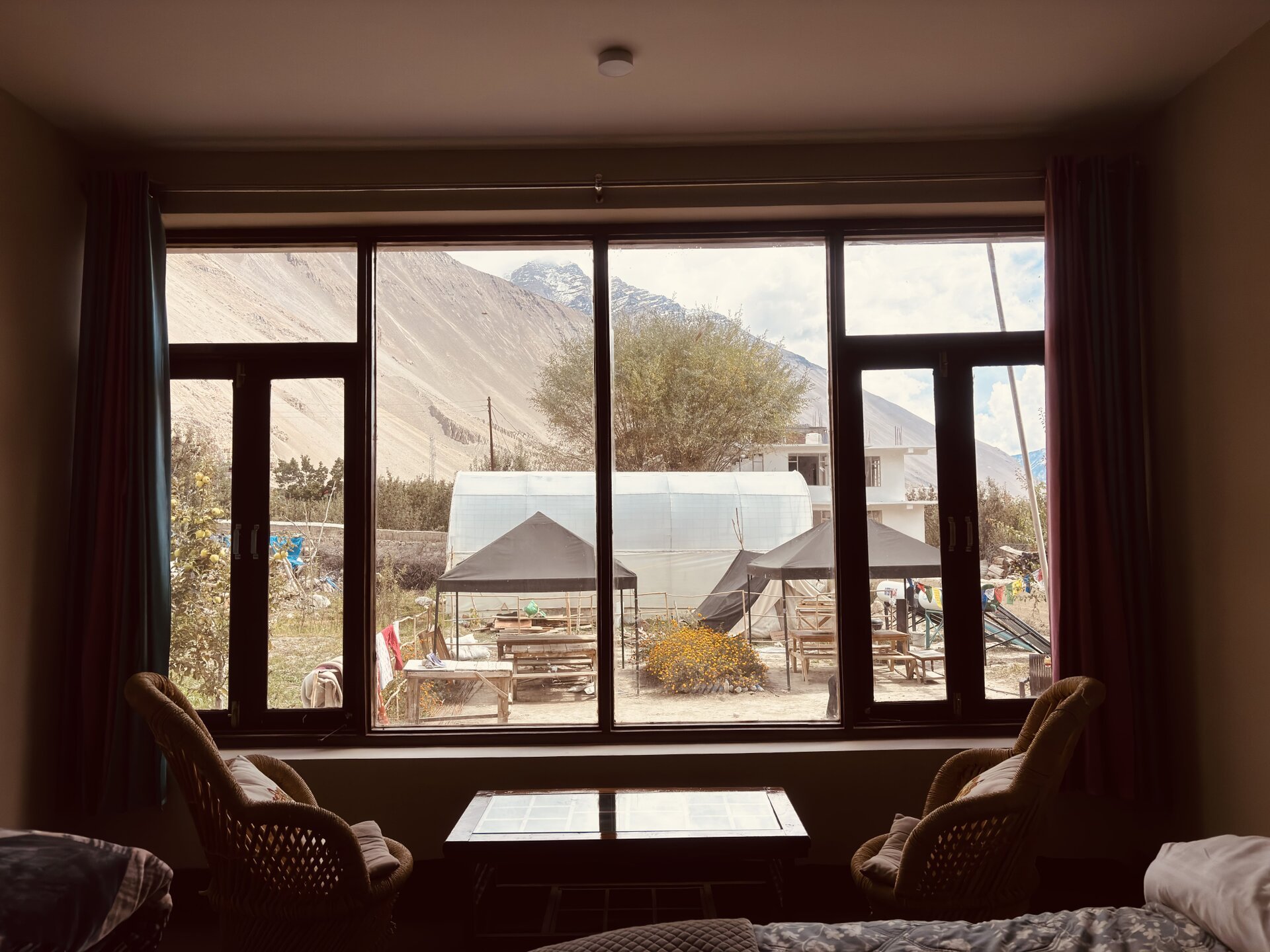 Breathtaking view of the surrounding mountains and greenery framed through a traditional wooden window at White Lotus Ho